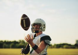 American football quarterback tossing a ball in the air