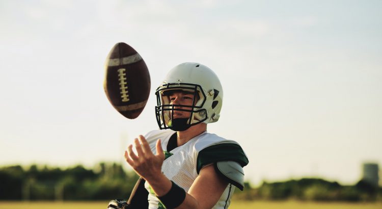 American football quarterback tossing a ball in the air